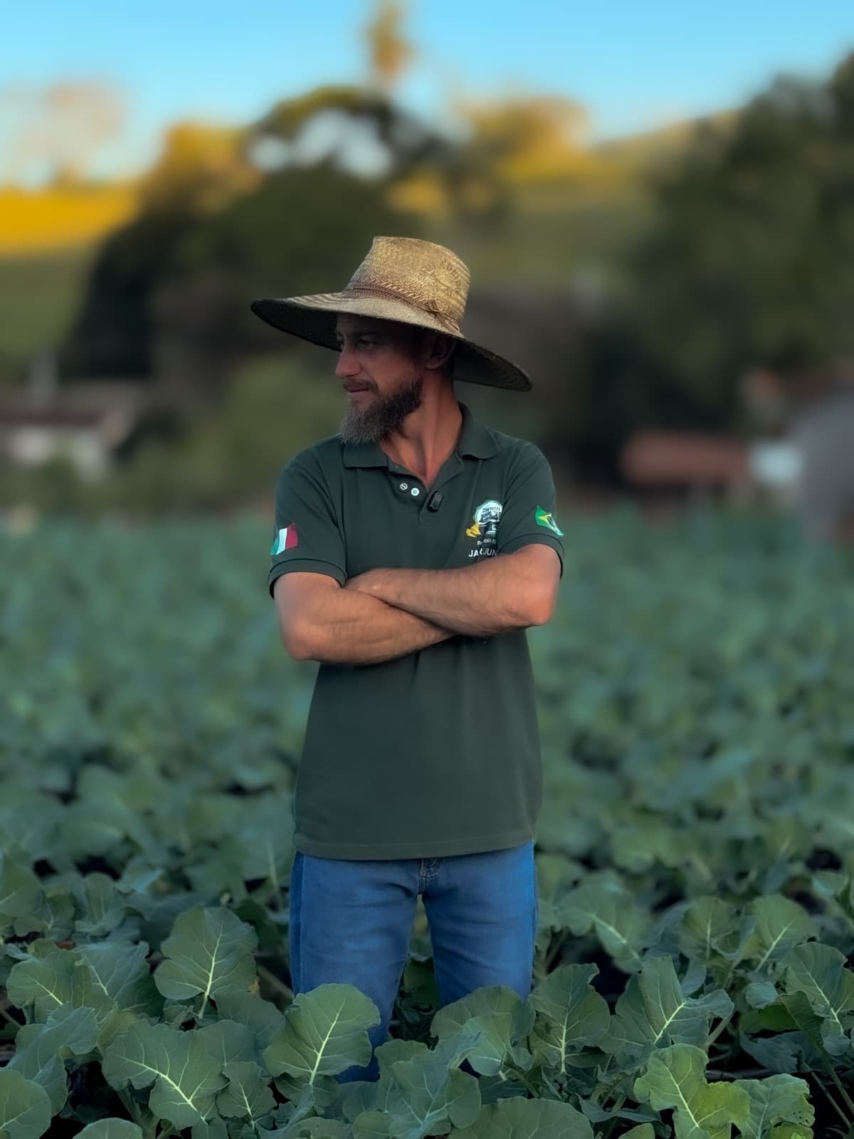 Juninho Campeão de braços cruzados no meio da plantação de brócolis